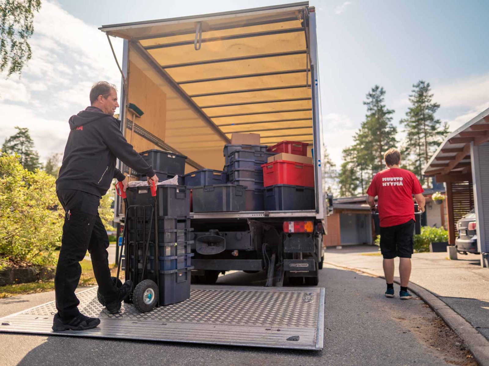 Muuttomiehet lastaavat laatikoita kuorma-autoon